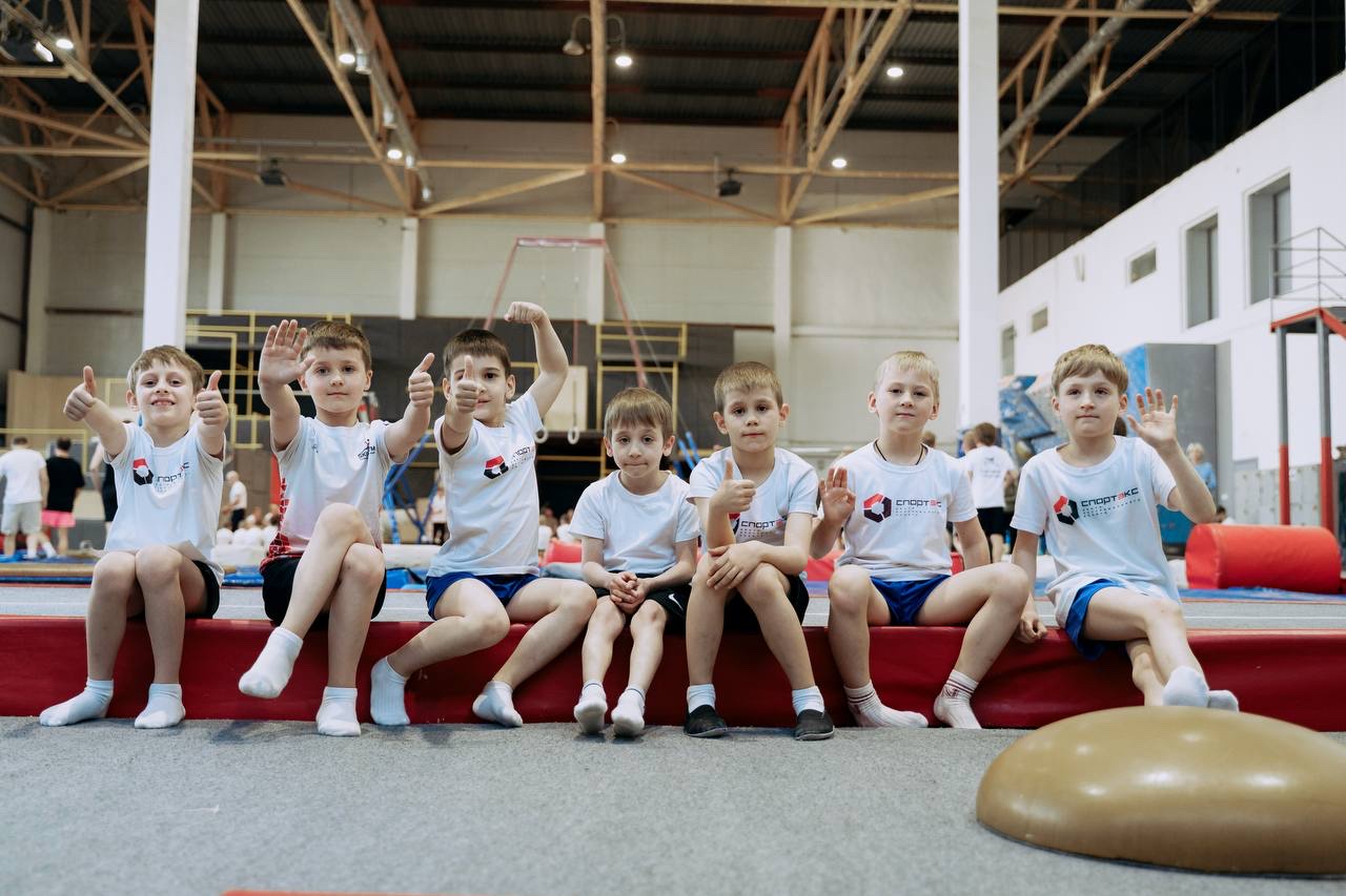 Юные гимнасты отдыхают после тренировки в просторном зале Спортэкса